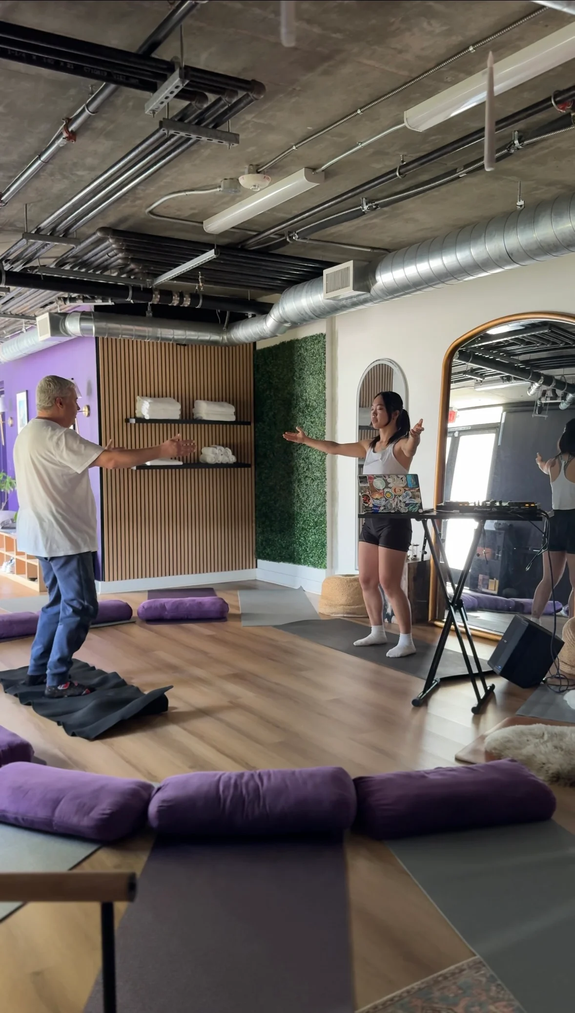 A Kelo lead guiding a participant through movement beside the music setup